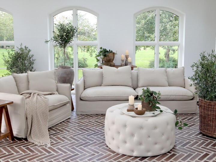 Marseilles sofa in natural linen, styled with neutral cushions in a bright living room with greenery.