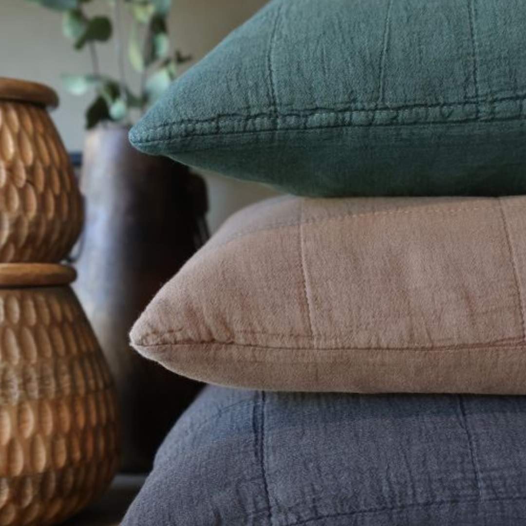 Chic cushions in soft green, blush and blue tones, featuring a relaxed textured finish and subtle stitched detailing.